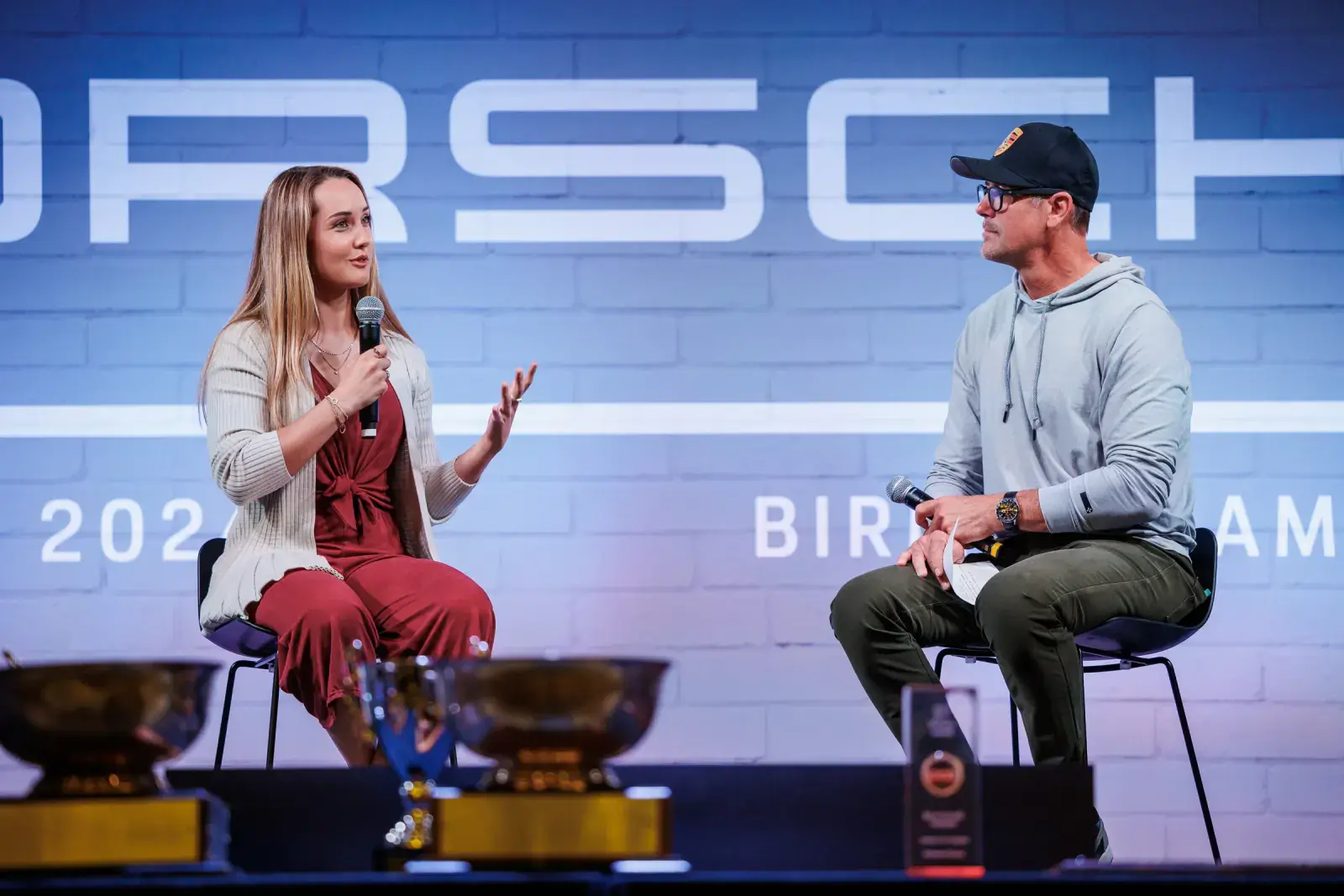 Sabré Cook giving a keynote talk at Porsche Parade 2024, addressing the audience as a media personality and expert speaker